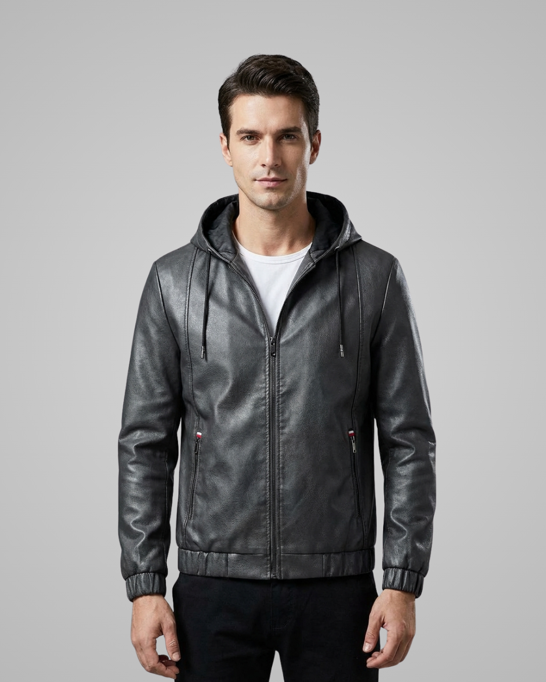 Man wearing a gray leather jacket with a hood on a gray background