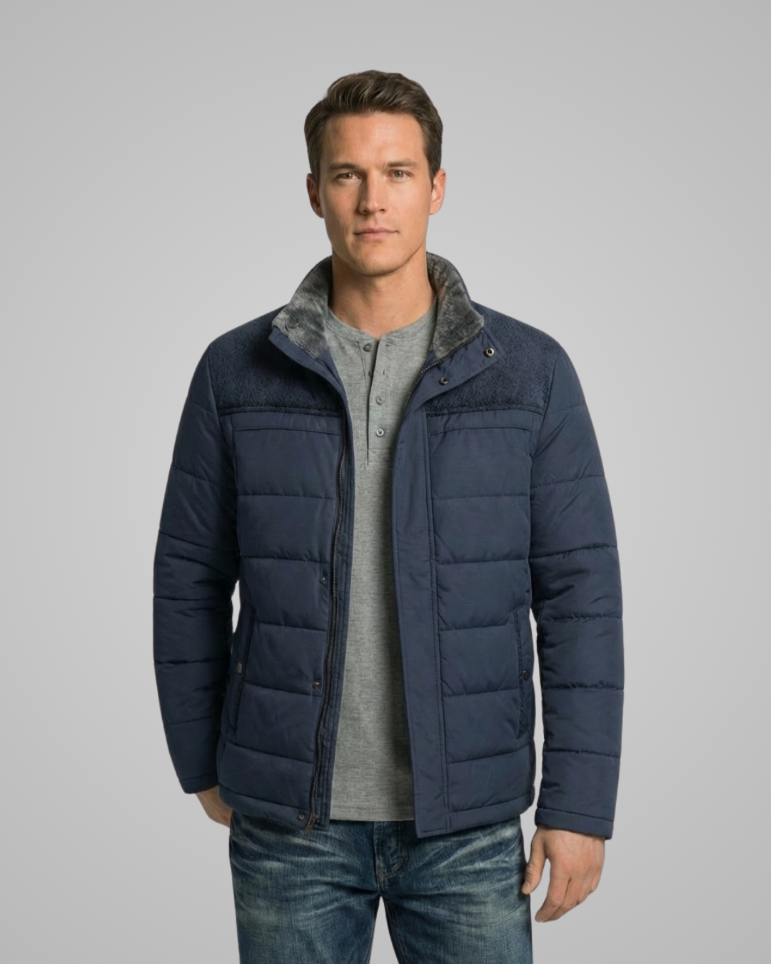 Man wearing a navy blue puffer jacket on a gray background