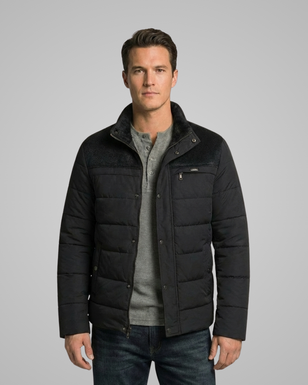 Man wearing a black puffer jacket on a gray background