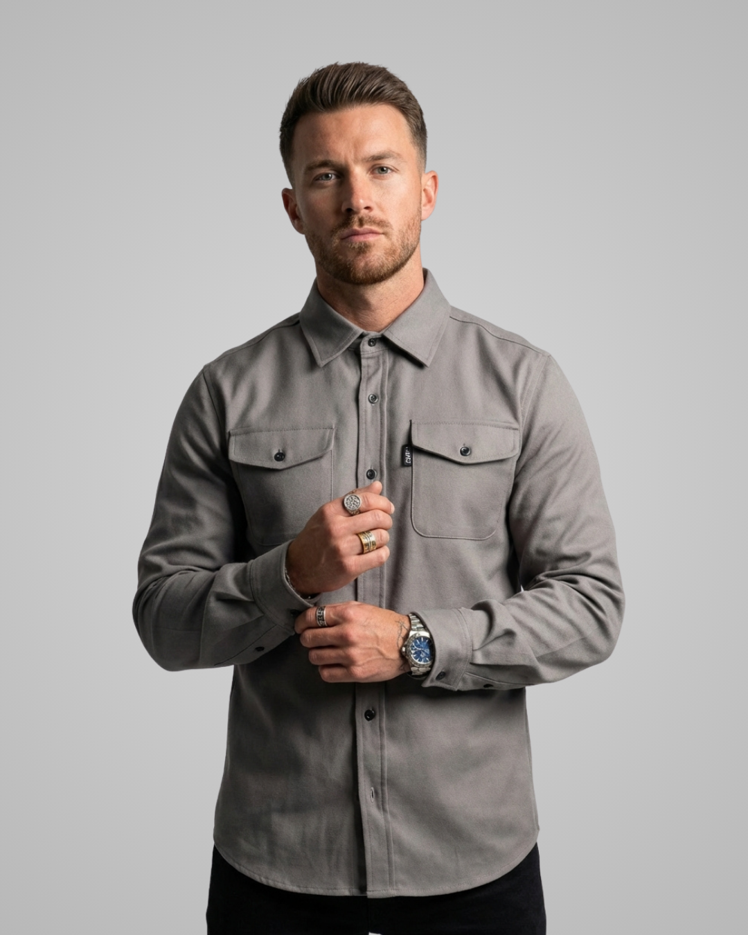 Man wearing a gray shirt against a plain background