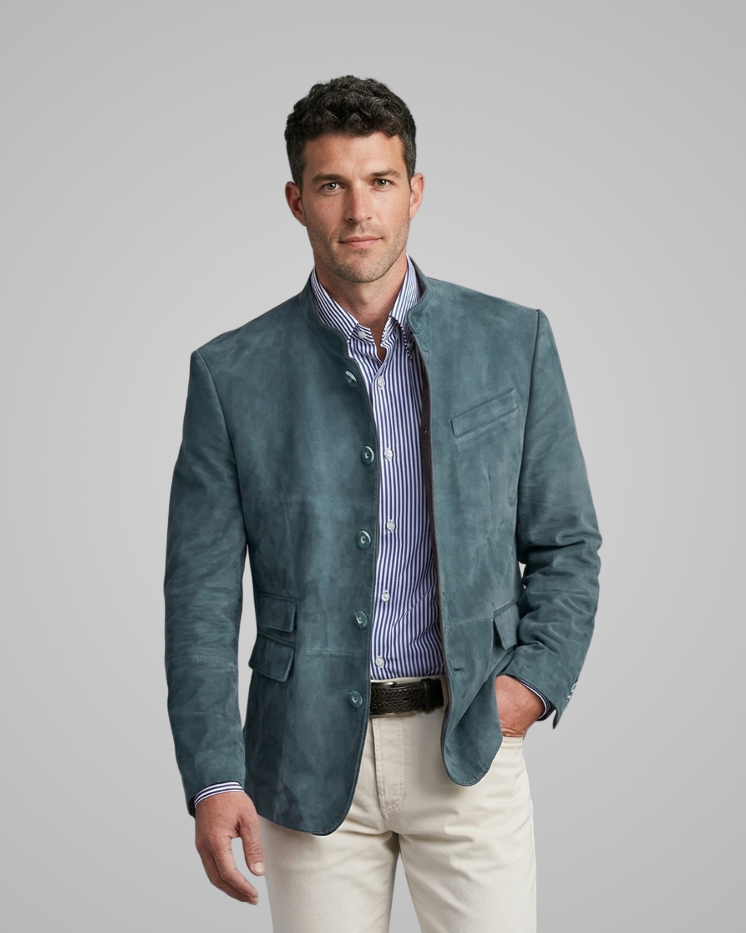 Man wearing a teal blazer over a striped shirt with a gray background