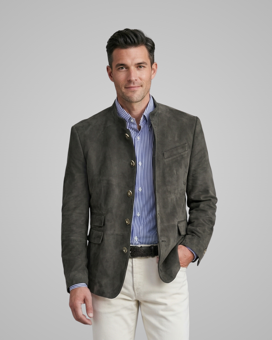 Man wearing a dark gray suede jacket over a striped shirt with a gray background