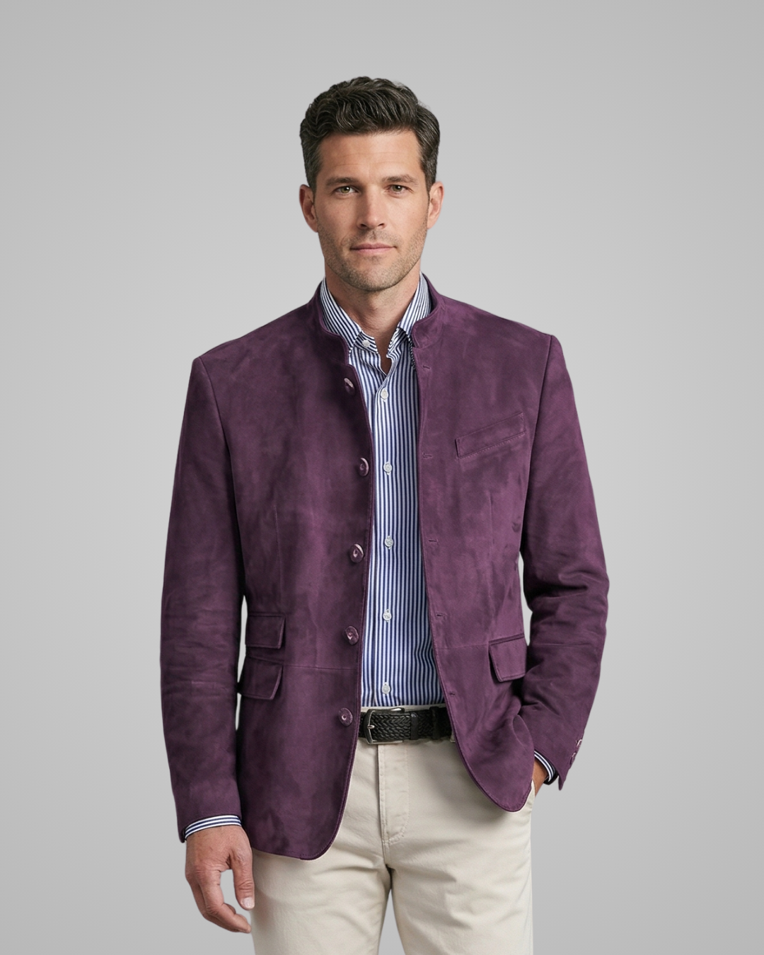 Man wearing a purple blazer over a striped shirt on a gray background