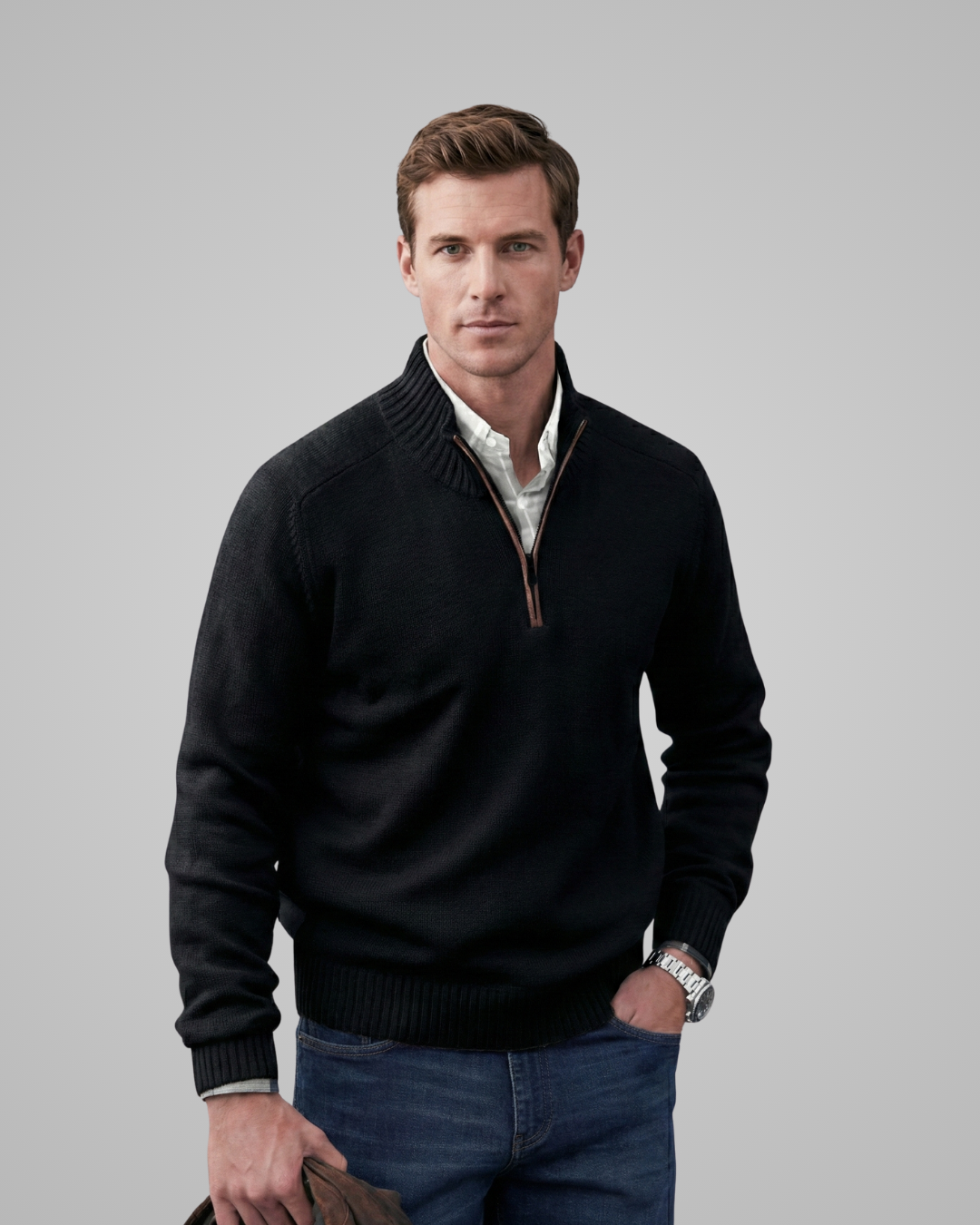 Man wearing a black quarter-zip sweater over a collared shirt on a gray background