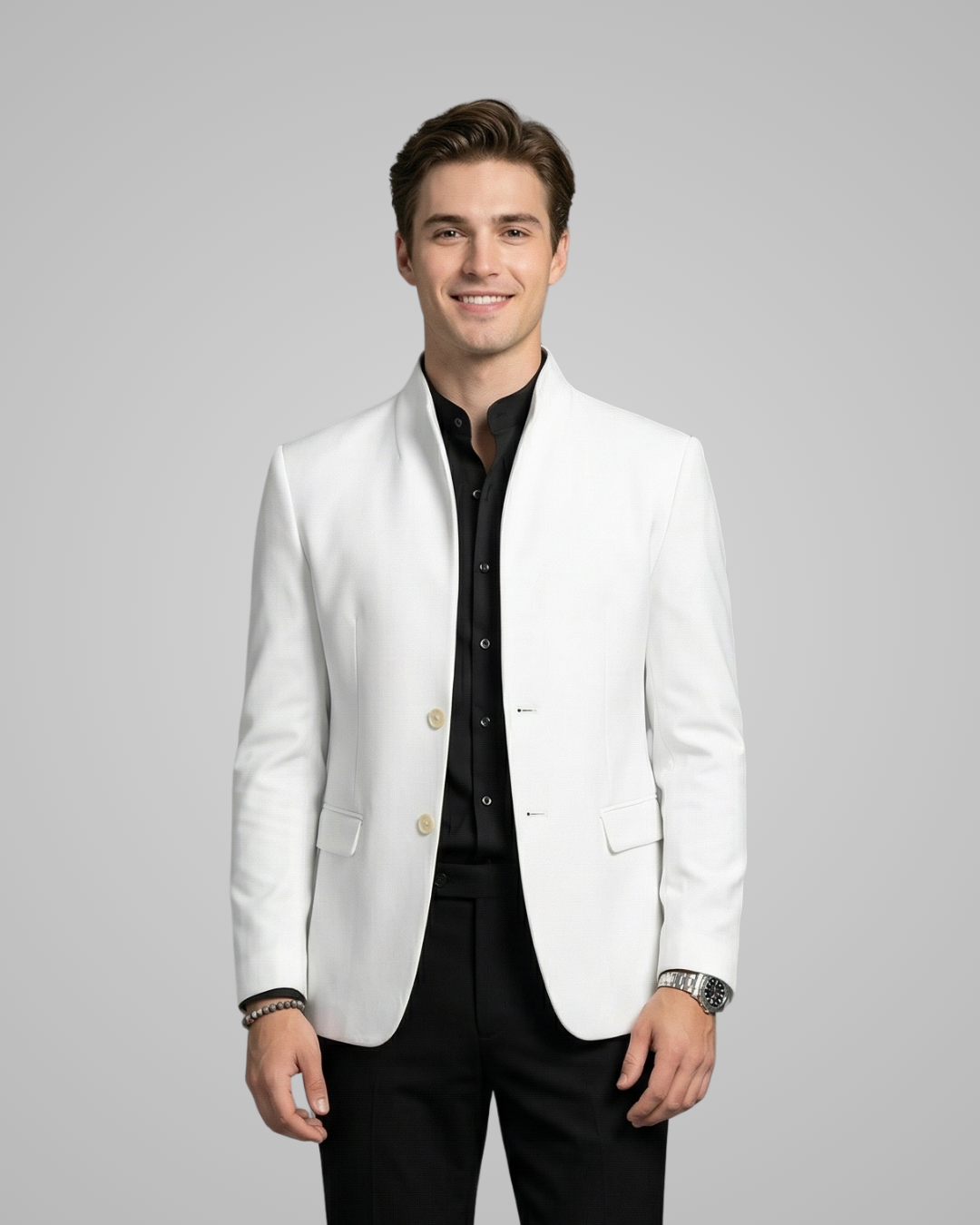 Man wearing a white blazer over a black shirt on a gray background