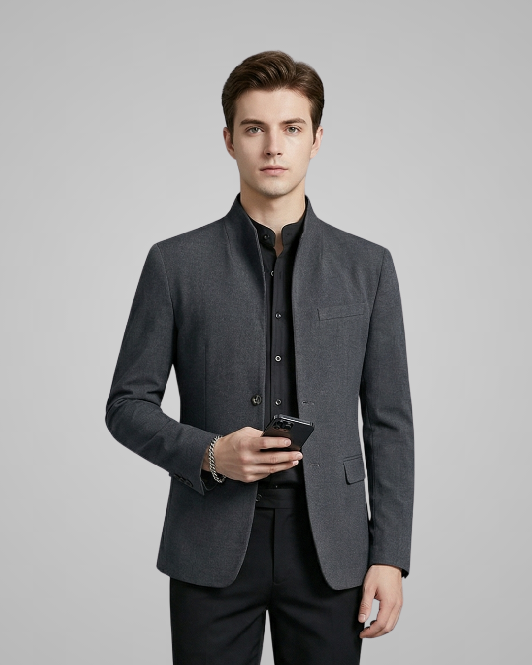Man wearing a gray blazer over a black shirt on a gray background