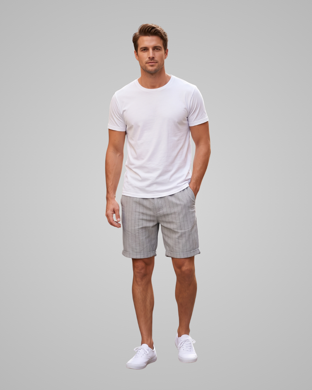 A man modeling a white crew-neck t-shirt and light gray pinstriped shorts against a solid gray studio background.