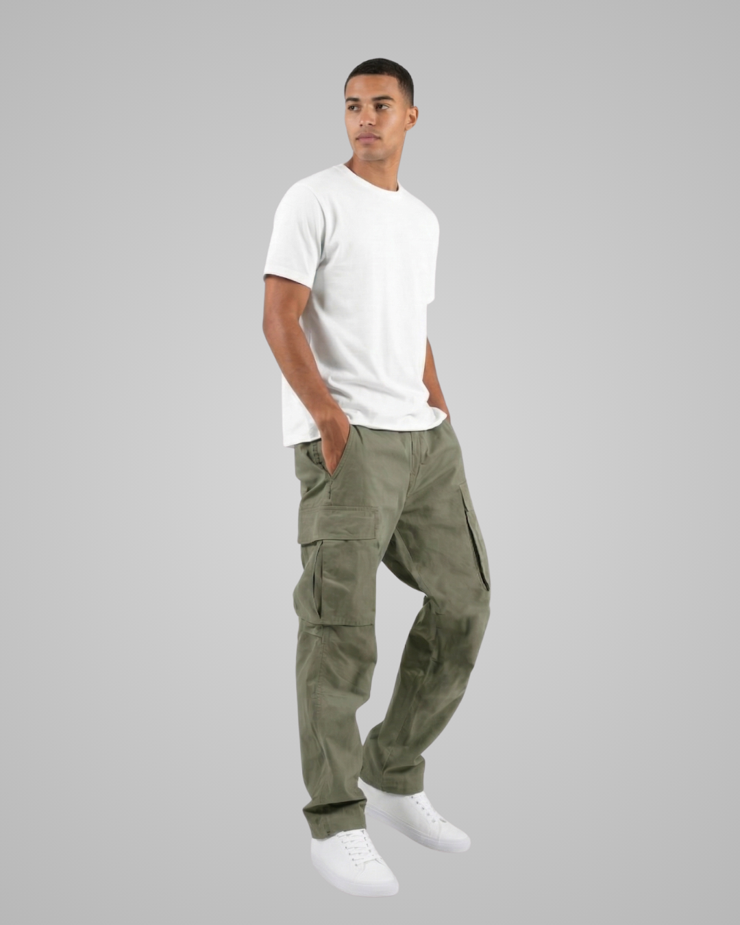 Man wearing green cargo pants and a white t-shirt on a gray background