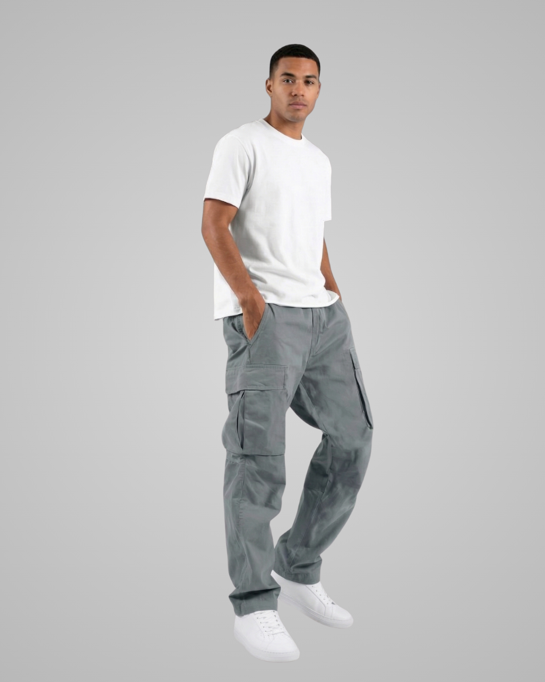 Man wearing gray cargo pants and a white t-shirt on a gray background