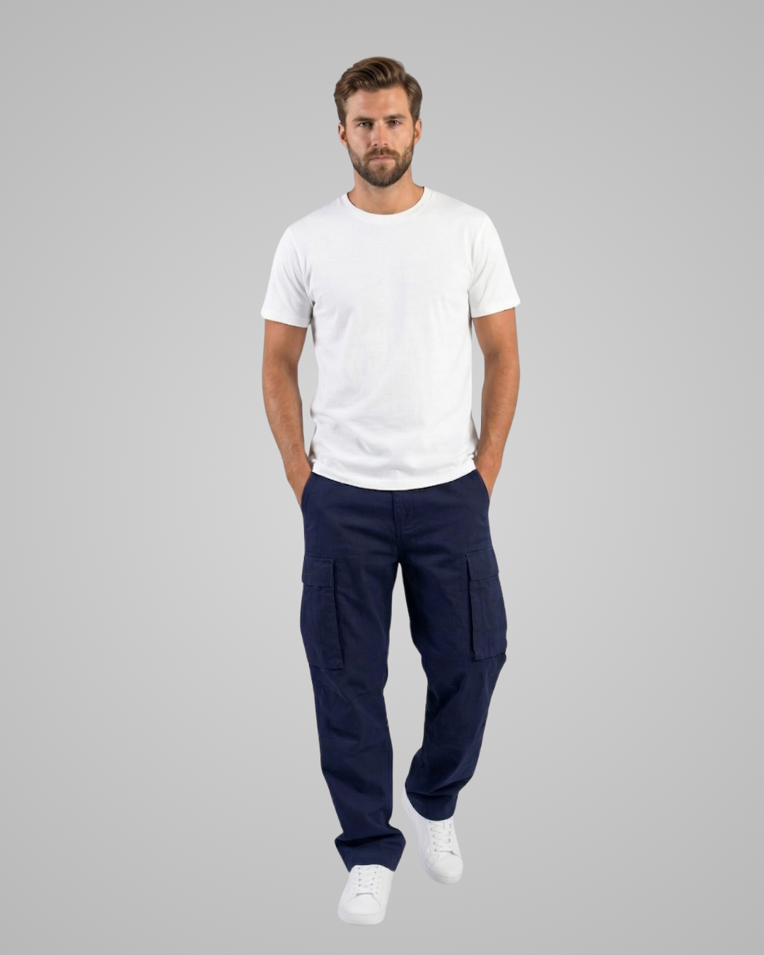 Man wearing a white t-shirt and navy cargo pants on a gray background
