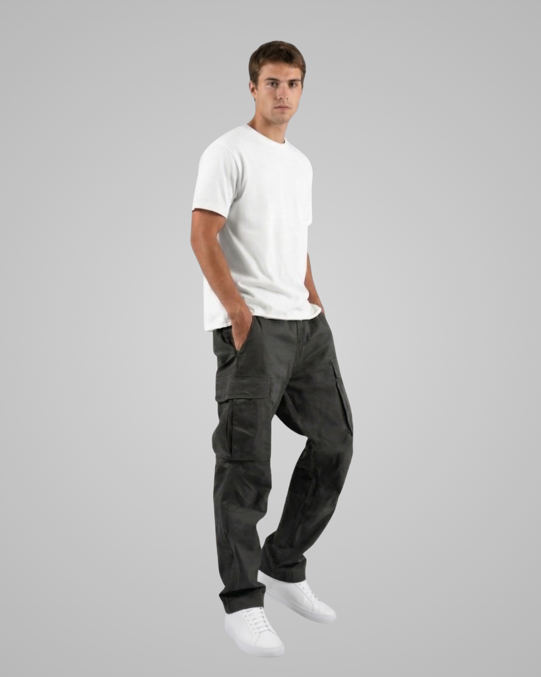 Man wearing black cargo pants and a white t-shirt on a gray background
