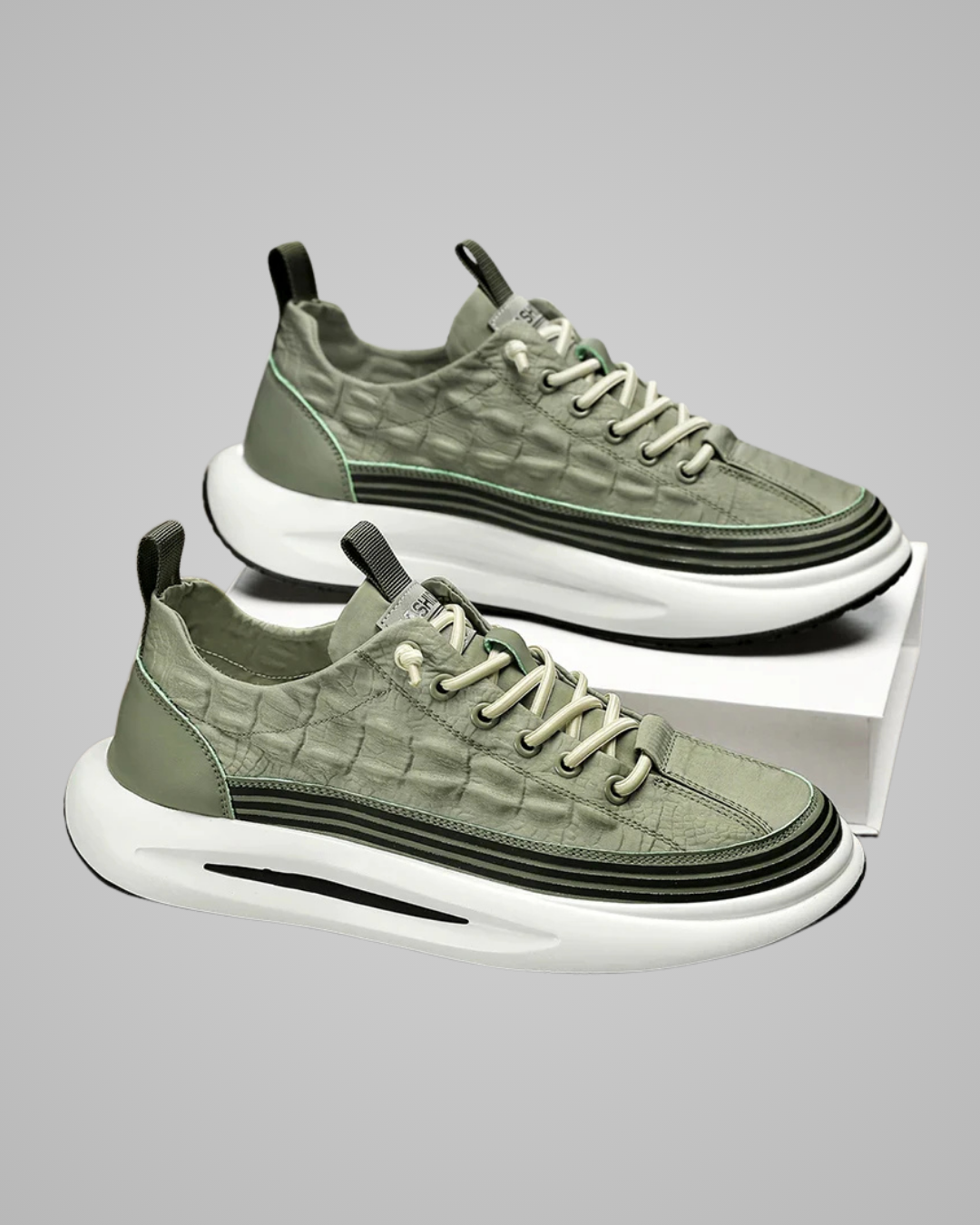 Pair of green sneakers with white soles on a gray background