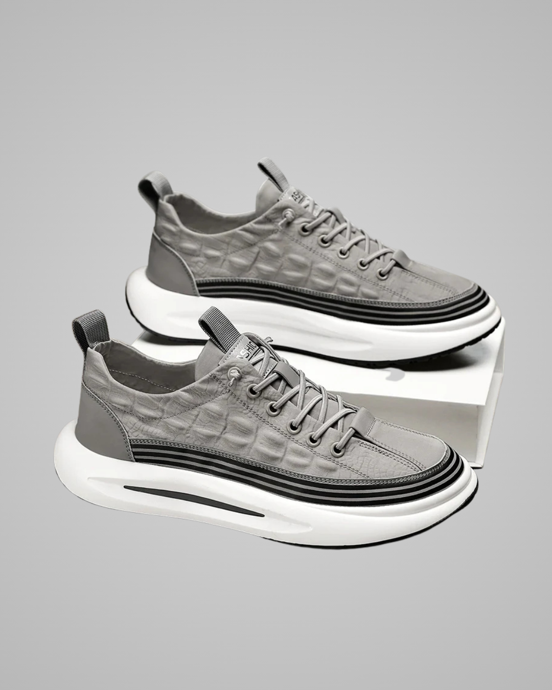 Gray sneakers with white soles on a reflective surface