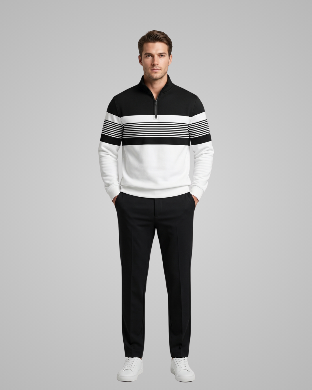 Man wearing a black and white striped sweater with black pants on a gray background