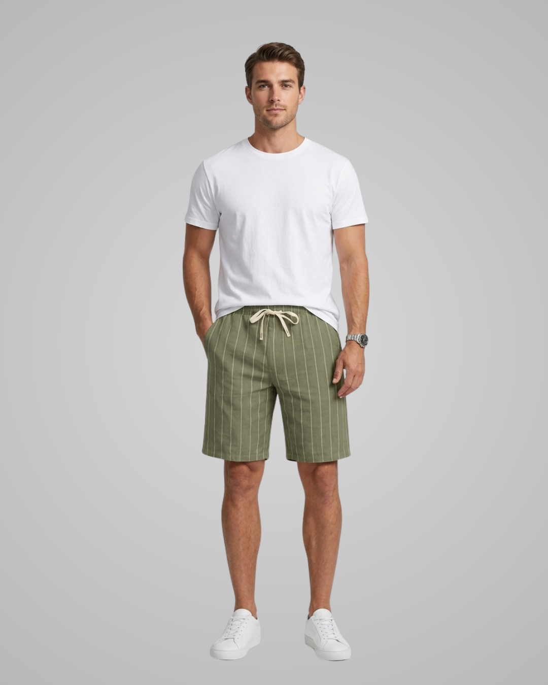 Man wearing a white t-shirt and green checkered shorts on a gray background
