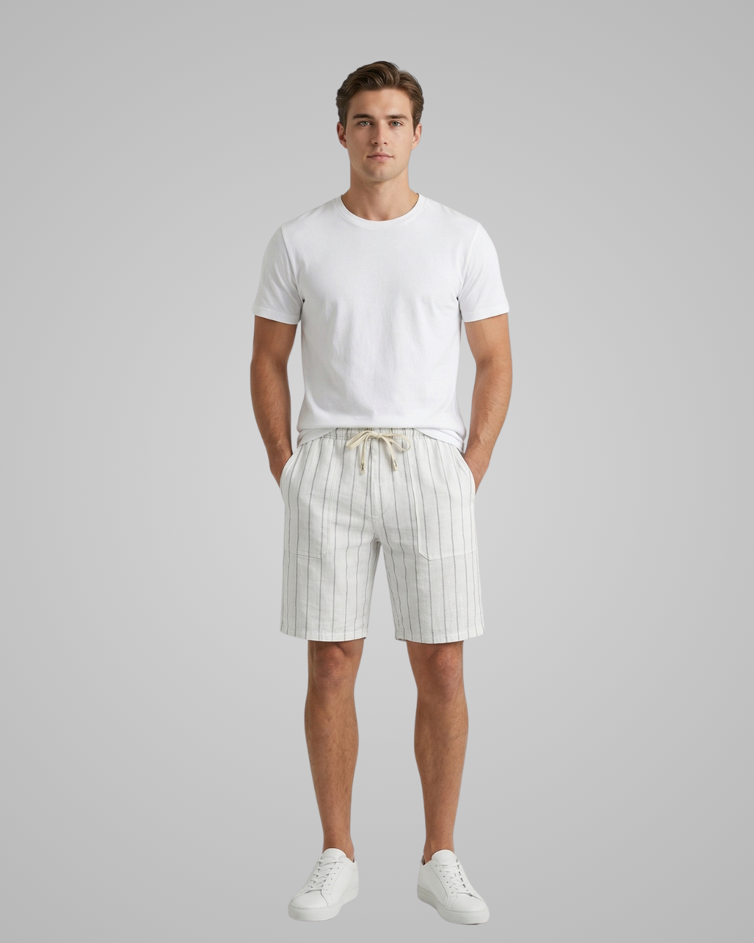 Man wearing a white t-shirt and striped shorts on a gray background