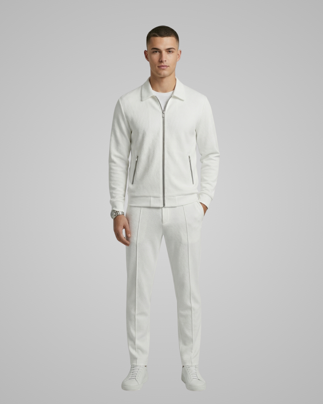 Man wearing a white tracksuit on a gray background
