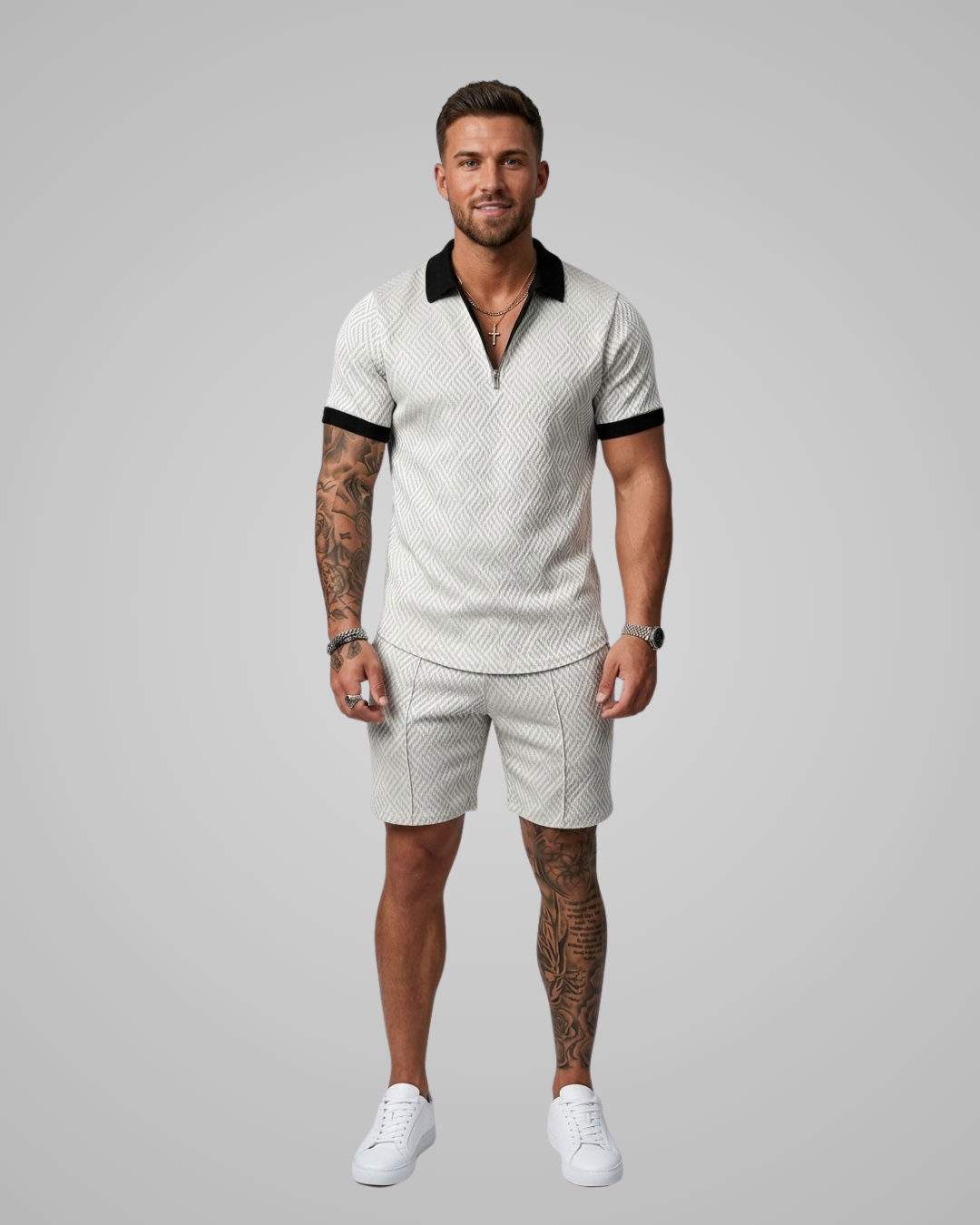 Man wearing a white patterned polo shirt and shorts set with black accents on a gray background
