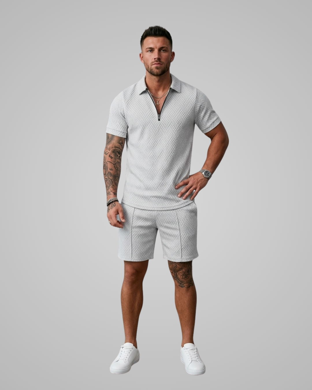 Man wearing a light gray patterned polo shirt and shorts set on a plain background