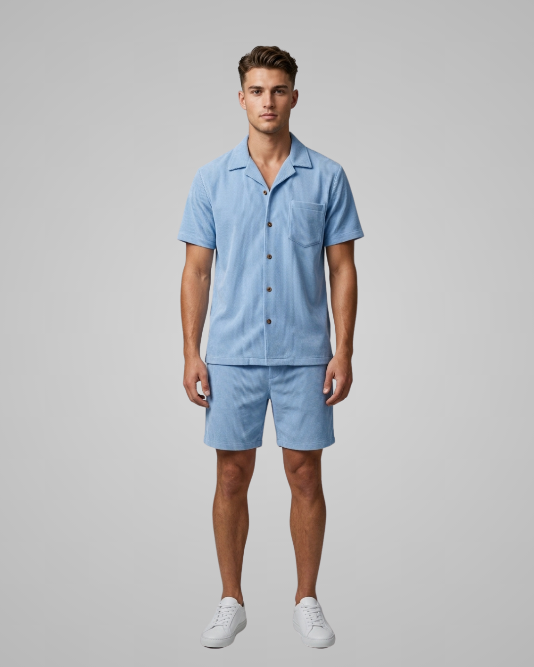 Man wearing a light blue shirt and shorts set on a gray background