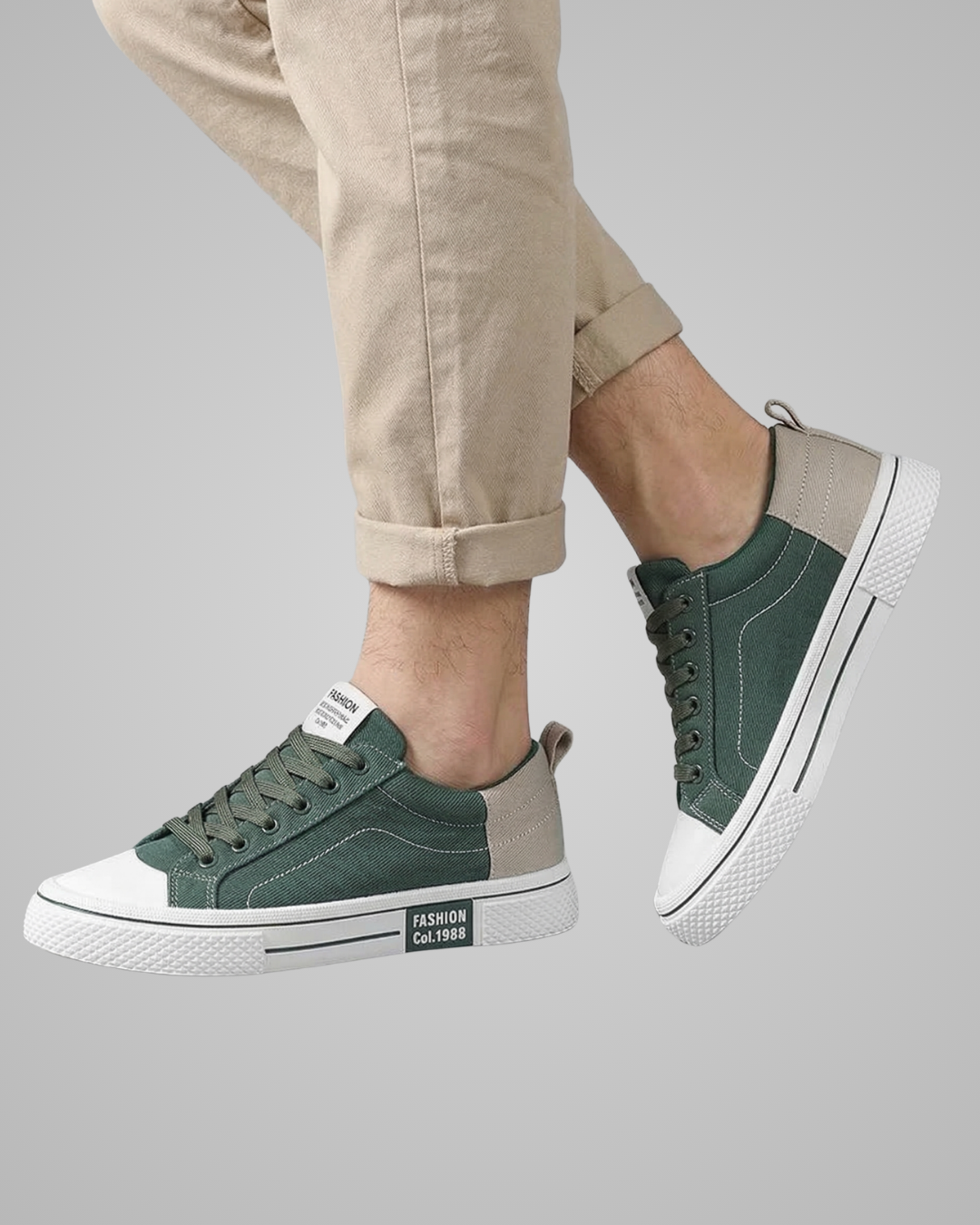 Green sneakers with white soles worn by a person on a gray background