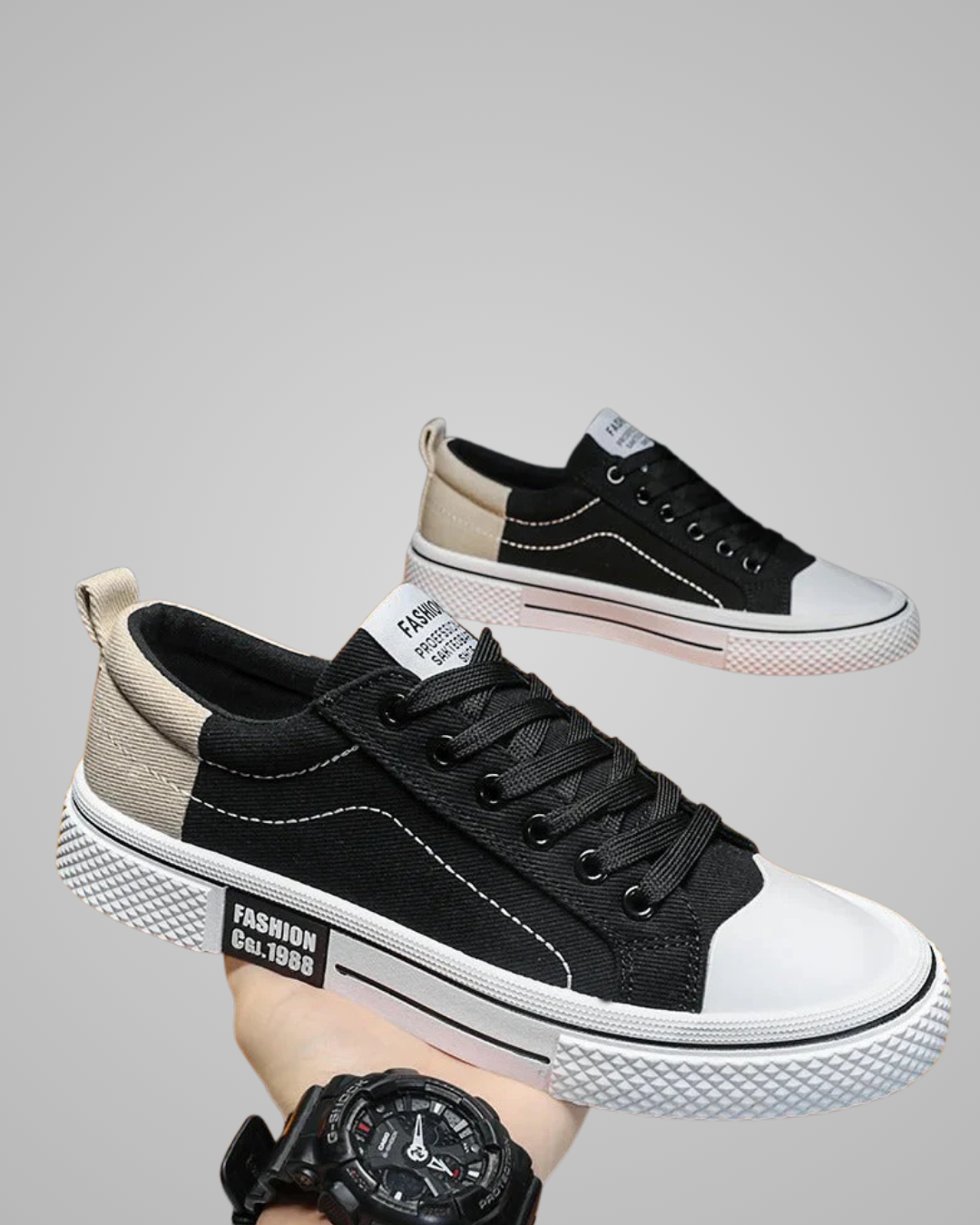 Black and white sneakers with a watch on a gray background