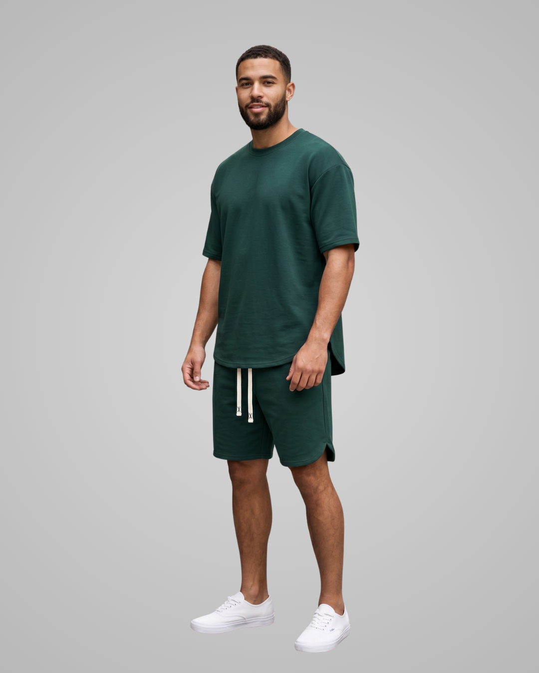 Man wearing a green t-shirt and shorts set on a gray background