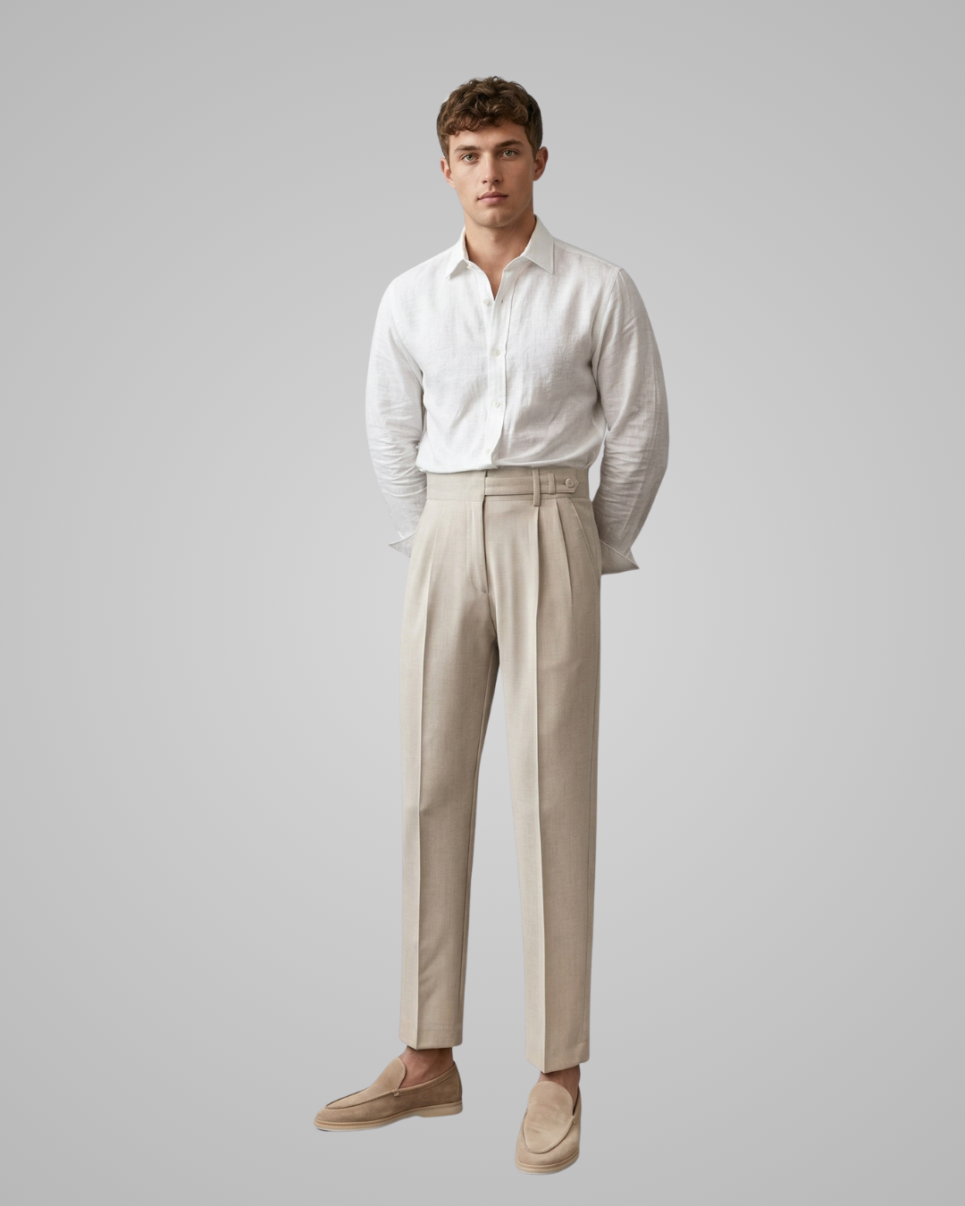 Man wearing a white shirt and beige pants against a gray background