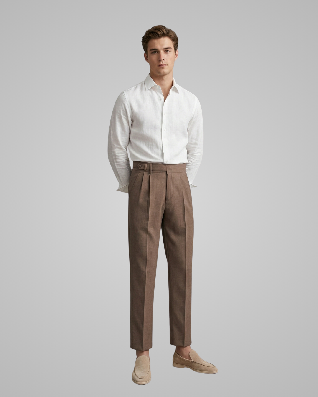 Man wearing a white shirt and brown pants on a gray background