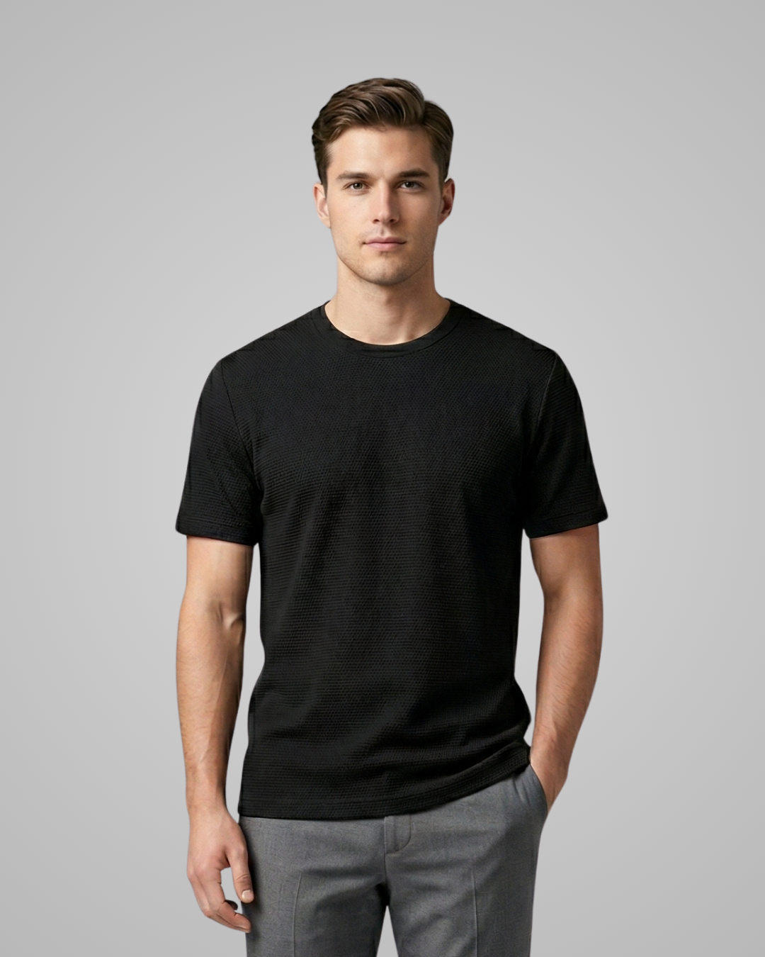 Man wearing a black t-shirt against a gray background