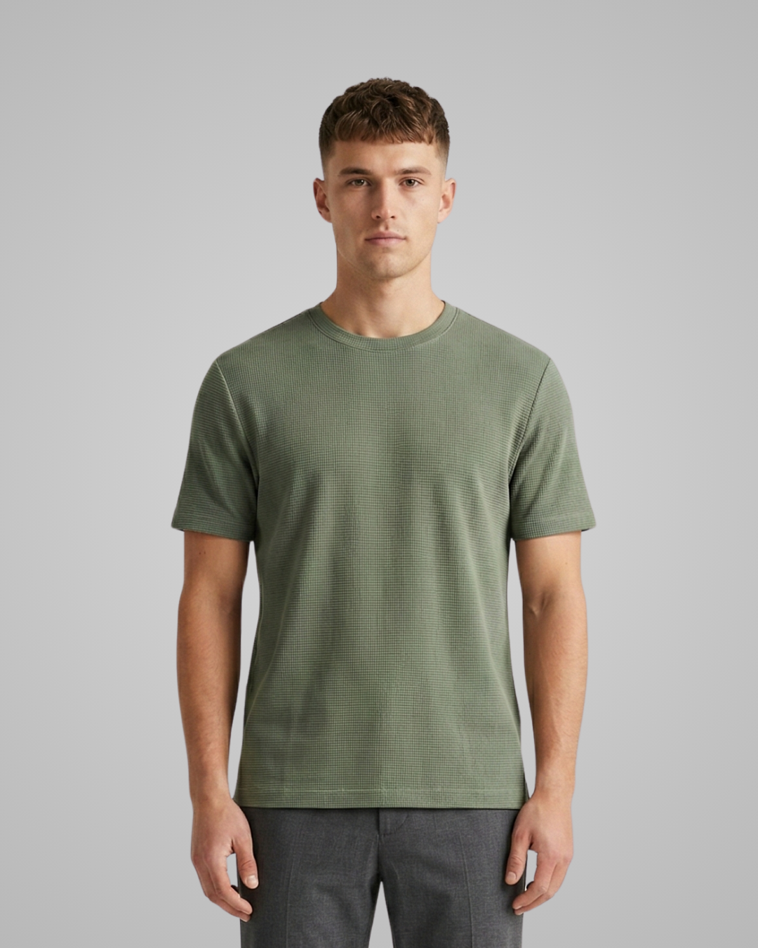 Man wearing a green t-shirt against a gray background