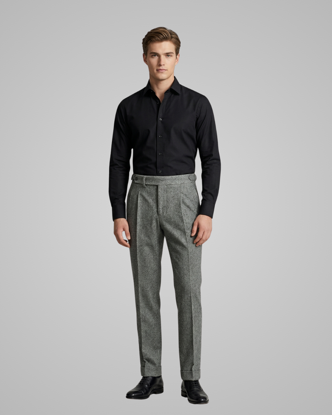 Man wearing a black shirt and gray pants on a gray background