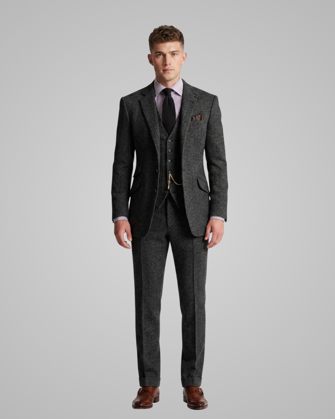 Man wearing a gray suit with a purple shirt and brown shoes on a gray background