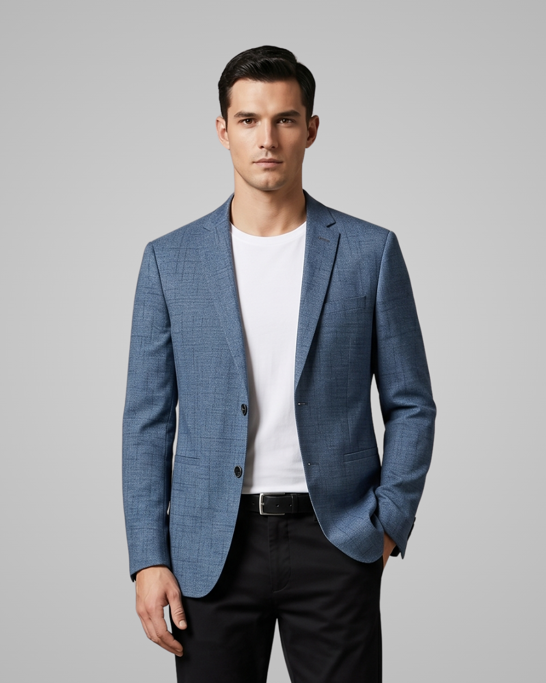 Man wearing a blue blazer over a white shirt on a gray background