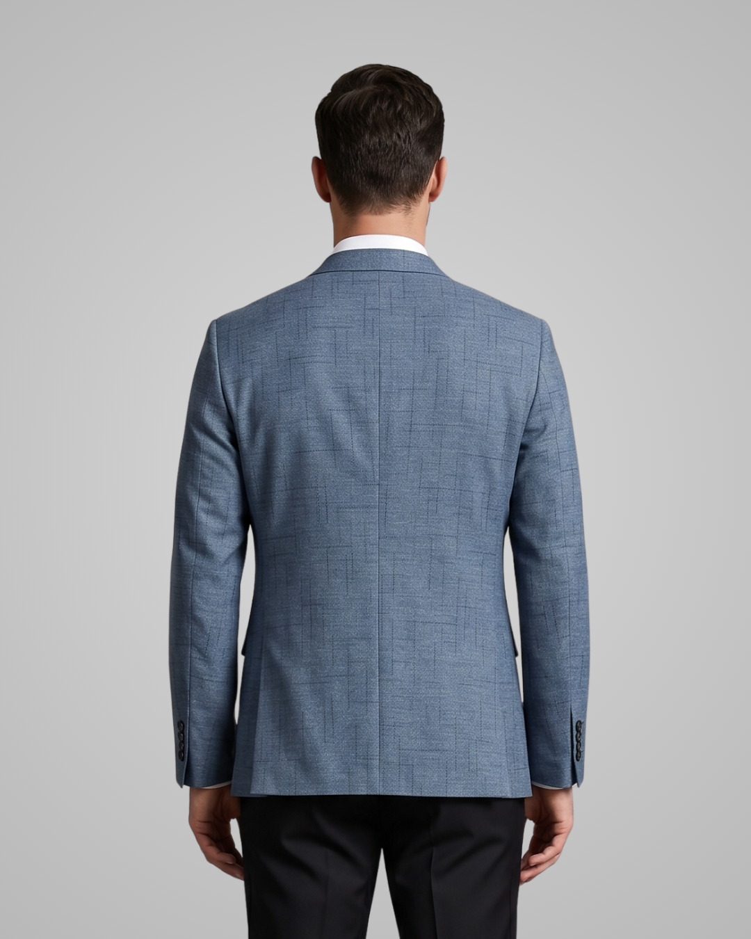 Man wearing a blue checkered suit jacket on a gray background