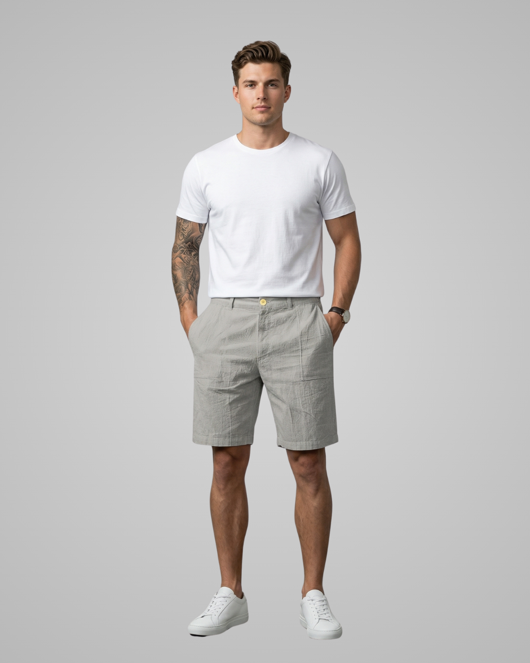 Man wearing a white t-shirt and light gray shorts on a plain background