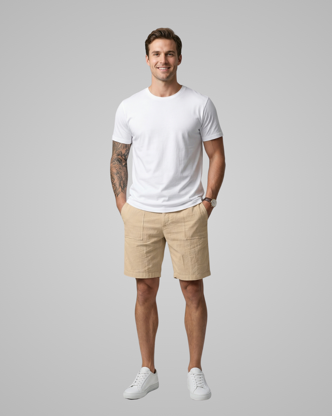 Man wearing a white t-shirt and beige shorts on a gray background
