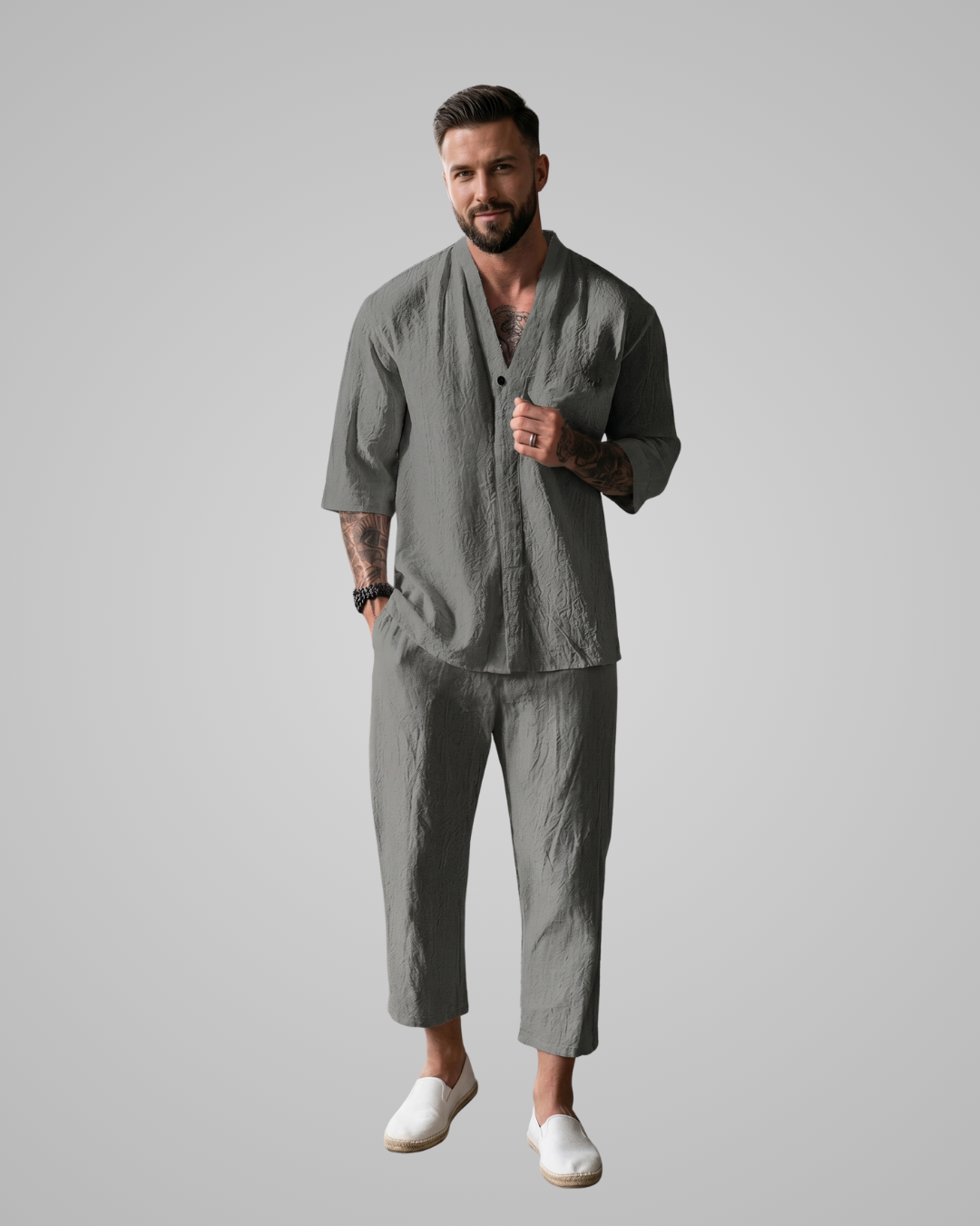 Man wearing a gray outfit with a plain background