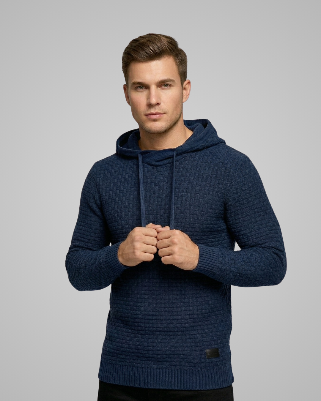 Man wearing a blue hoodie against a gray background