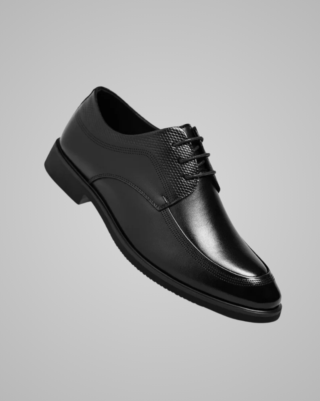 Black leather dress shoe on a gray background
