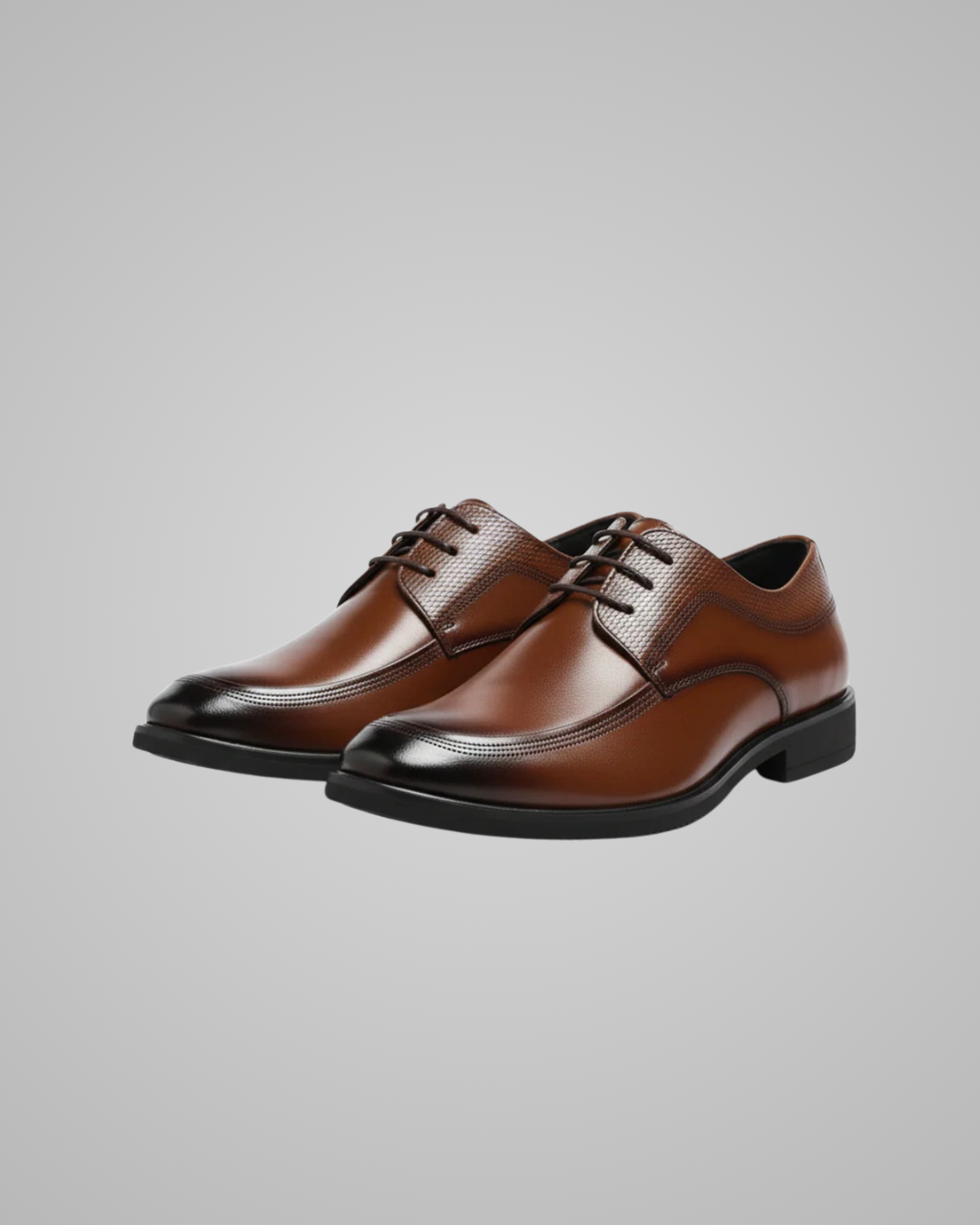 Pair of brown leather dress shoes on a gray background