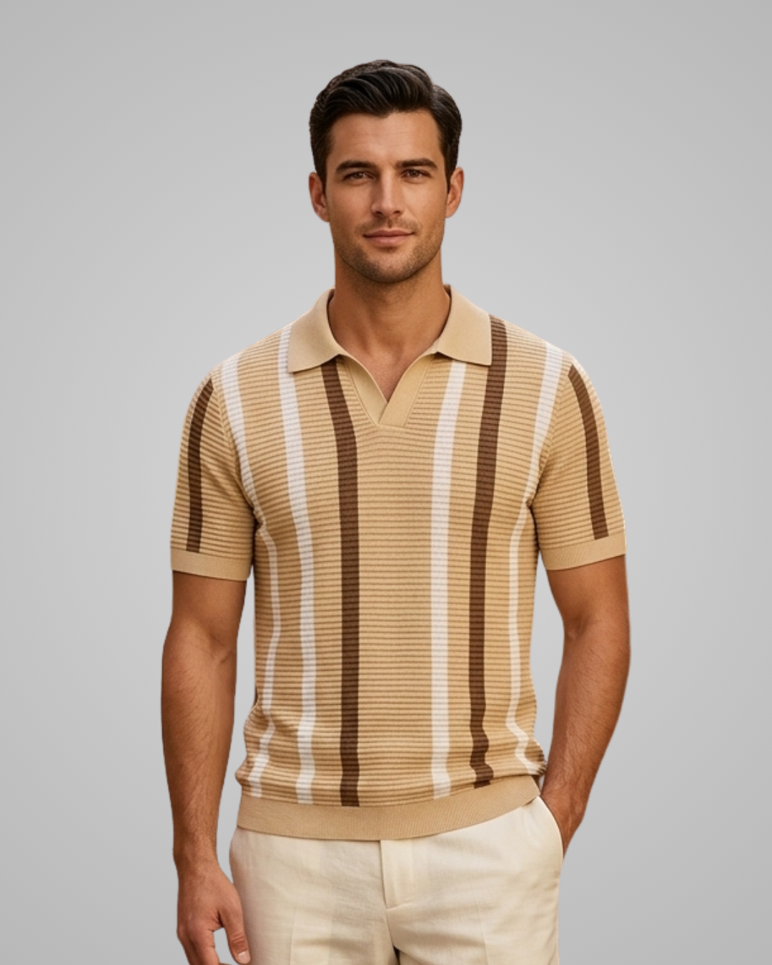 A man wearing a beige and brown vertically striped ribbed knit polo shirt with cream pants, standing against a solid gray studio background.
