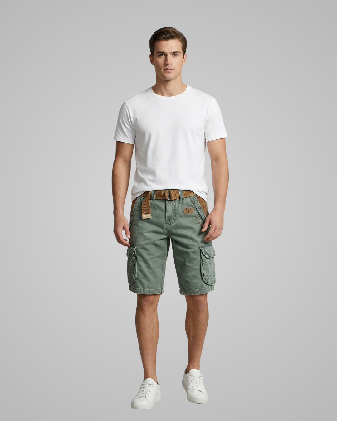 Man wearing a white t-shirt and green cargo shorts on a gray background