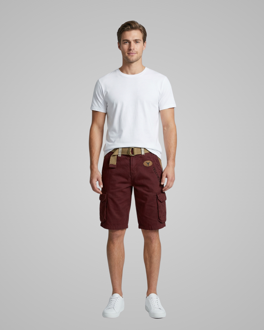 Man wearing a white t-shirt and maroon cargo shorts on a gray background