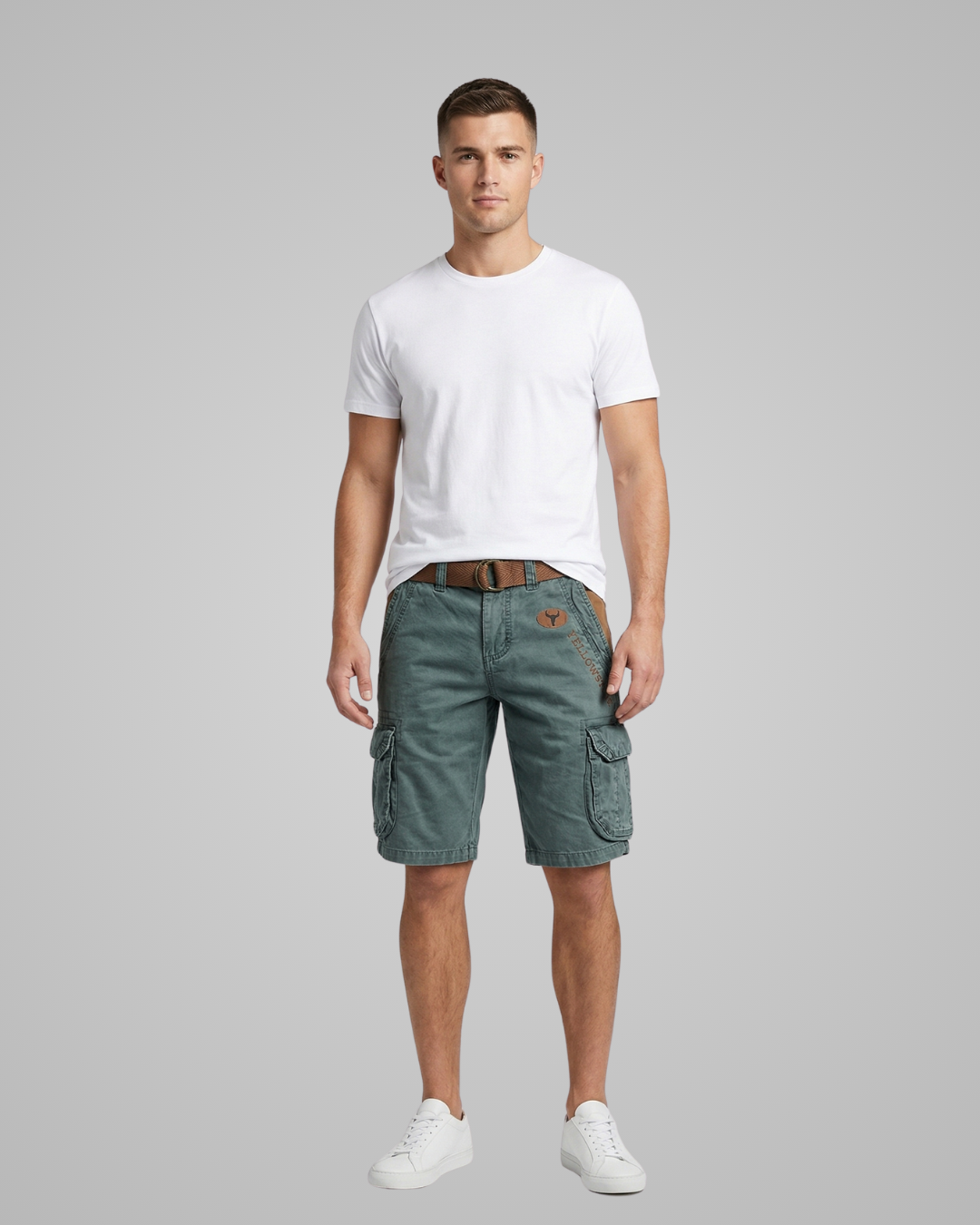 Man wearing green cargo shorts and a white t-shirt on a gray background