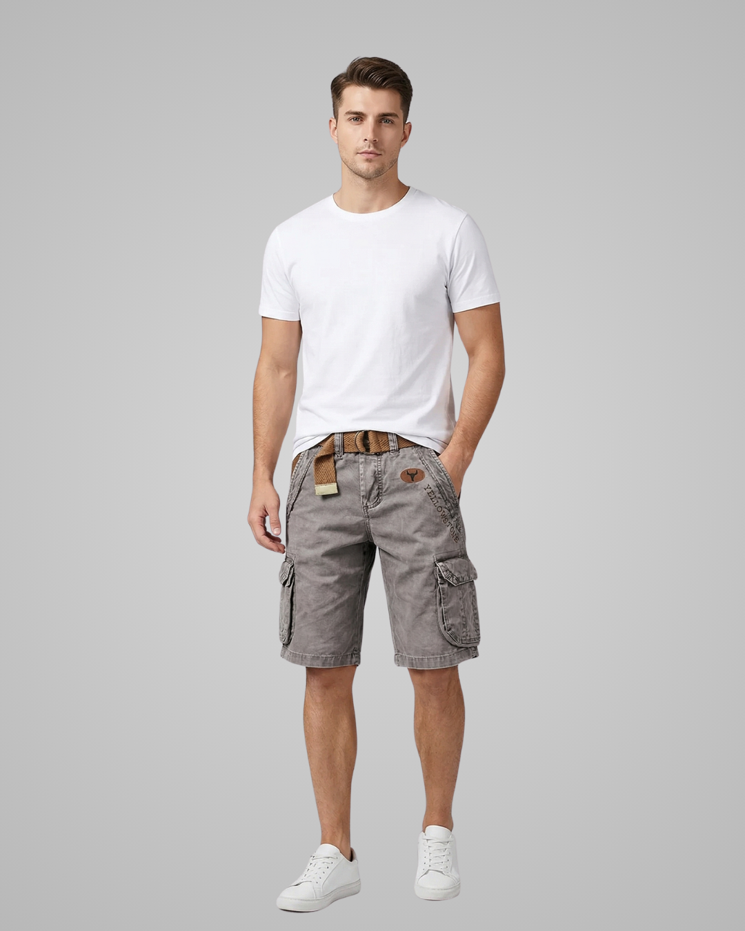 Man wearing a white t-shirt and gray cargo shorts on a gray background