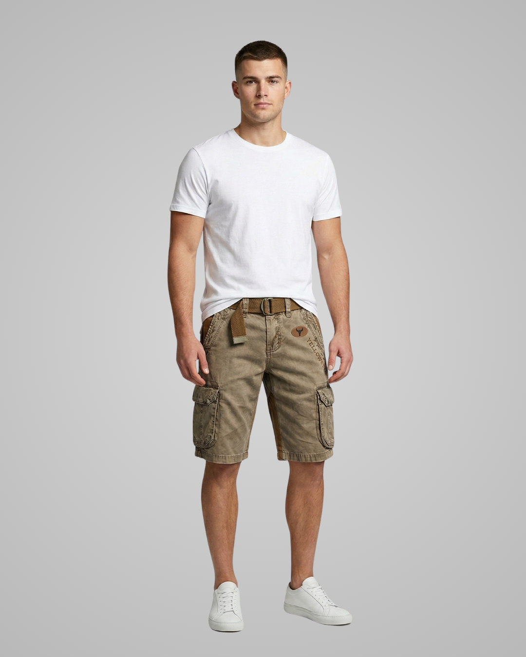 Man wearing a white t-shirt and green cargo shorts on a gray background
