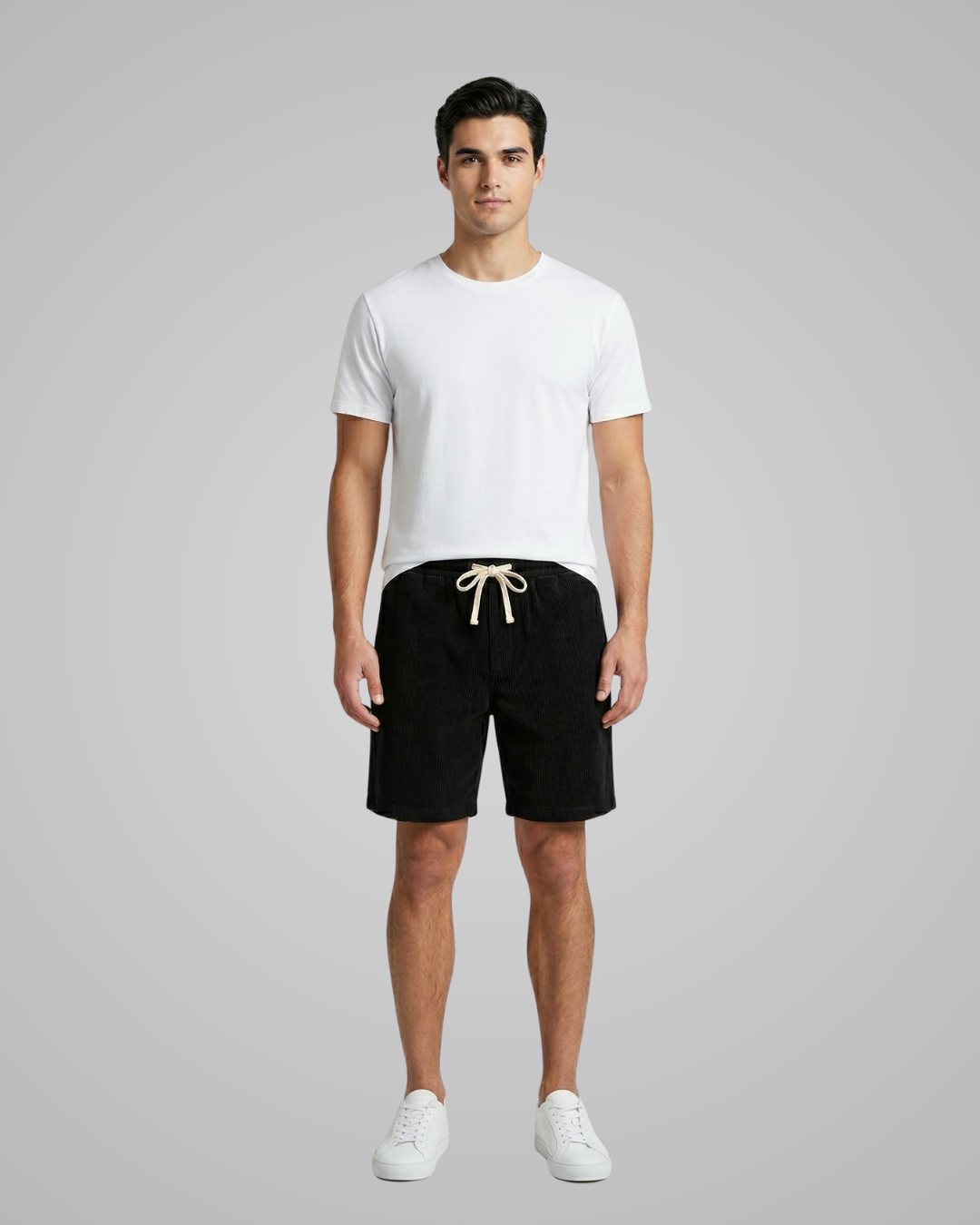 Man wearing a white t-shirt and black shorts on a gray background