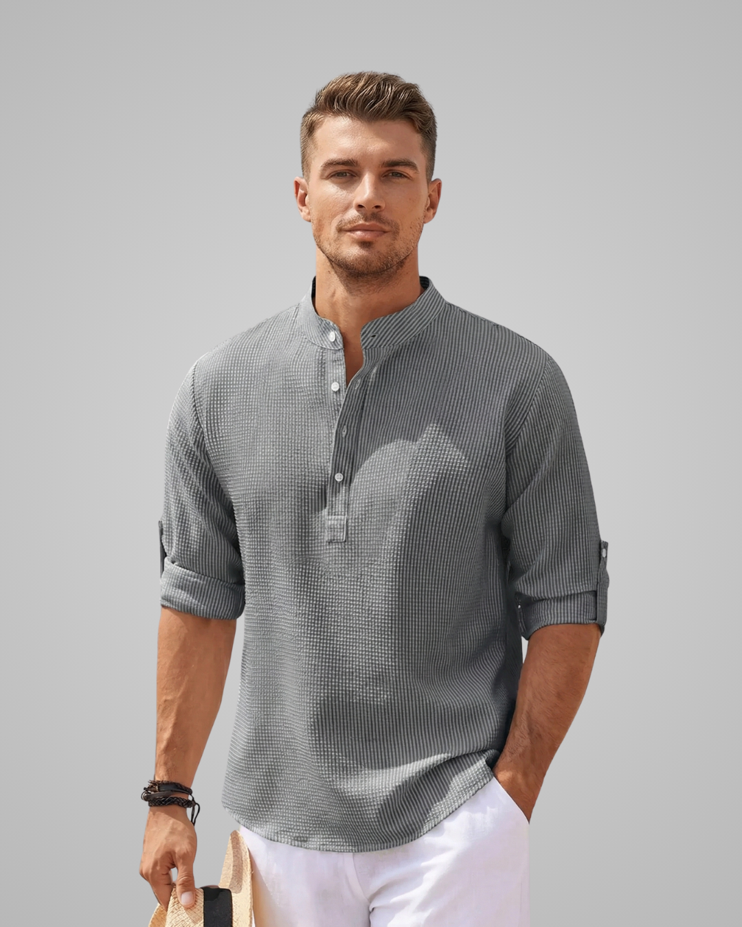 Man wearing a gray patterned shirt with a plain background