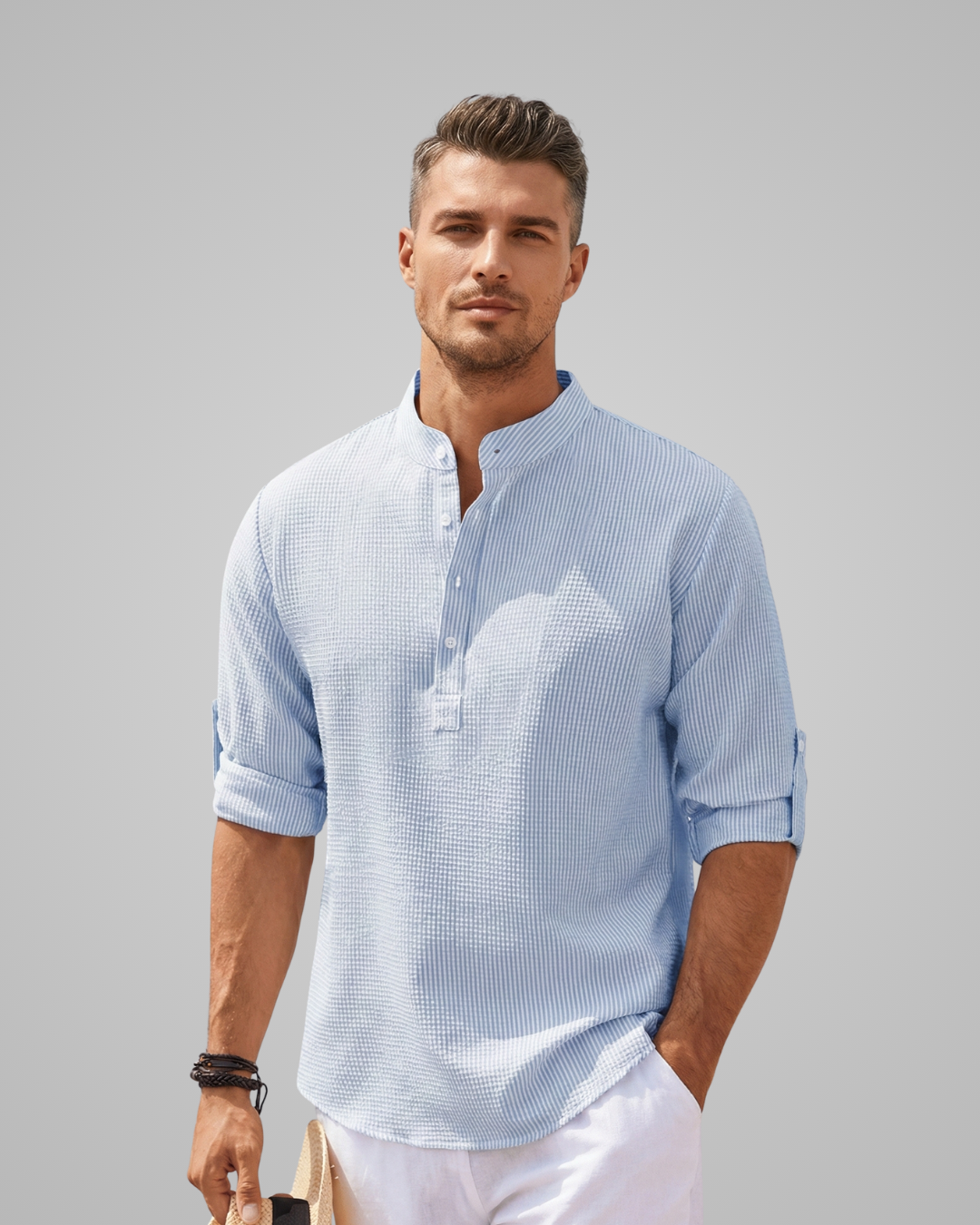 Man wearing a light blue striped shirt with a gray background